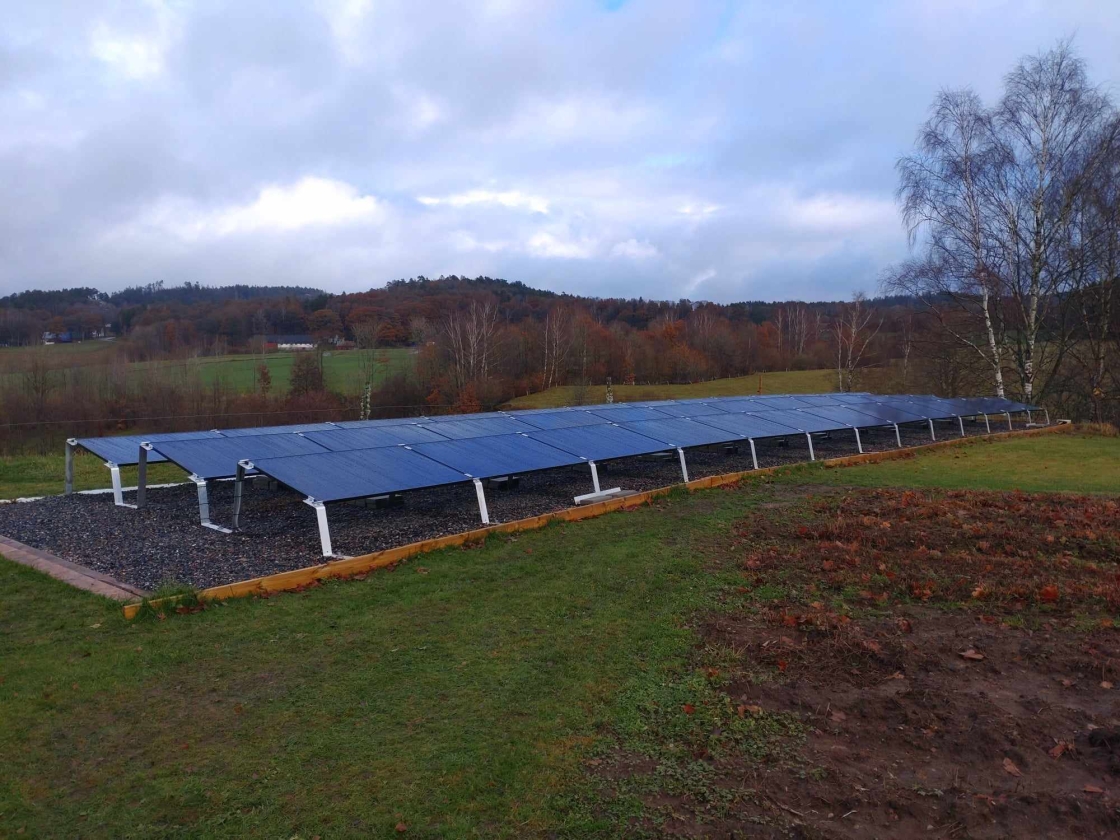 Solceller monterade i trädgård.